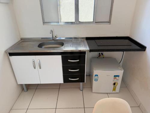 a small kitchen with a sink and a window at Golden Stay Suites in Jacareí