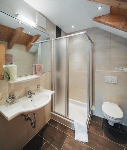 a bathroom with a shower and a sink and a toilet at Apart Waldblick in Serfaus