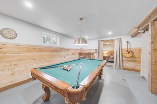 a pool table in a room with wooden walls at Pool Table et Nature - Chalet de la riviere in Saint-Alexis-des-Monts