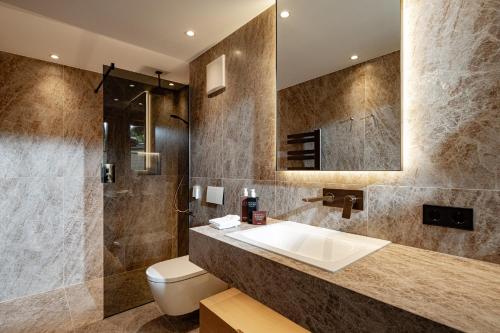a bathroom with a sink and a toilet at Boutique Hotel Nives - Luxury & Design in the Dolomites in Selva di Val Gardena