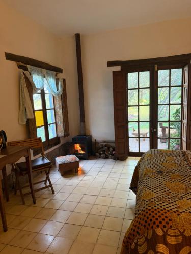 a bedroom with a fireplace and a bed and a table at Varuna- en La Casa de Nanda in San Javier