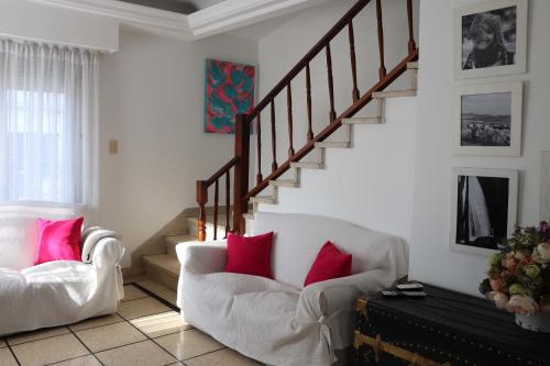 a living room with two chairs and a staircase at Chalet 3 dormitorios MDP in Mar del Plata