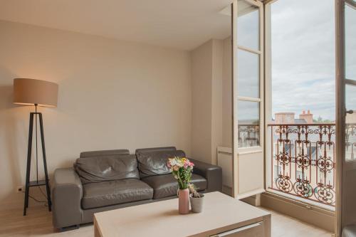 a living room with a couch and a table at Le Doumer - Centre-ville - Petfriendly in Château-Gontier