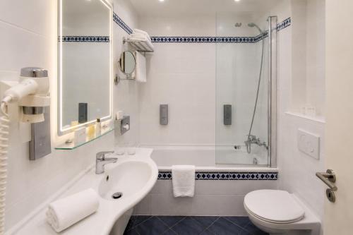 ein Badezimmer mit Waschbecken, Dusche und Toilette in der Unterkunft Hotel Mediterran Budapest in Budapest