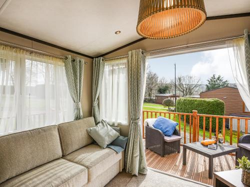 a living room with a couch and a balcony at Avon Lodge in Hyssington