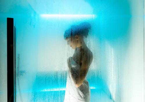 a man with an umbrella standing behind a window at Hotel La Perla Wellness & Beauty in Canazei