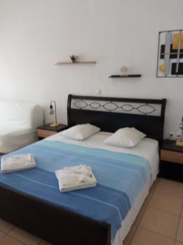 a bedroom with a bed with two towels on it at Blue Bay Club in Vrachonisída Omprélla