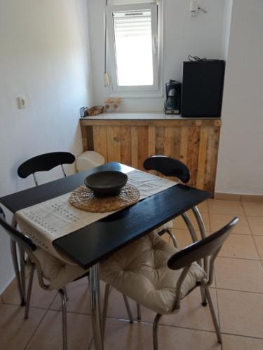 a table and chairs in a kitchen with a window at Blue Bay Club in Vrachonisída Omprélla