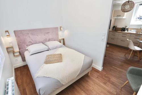 a bedroom with a large white bed in a room at Le Corail - centre-ville - TV in Pontivy