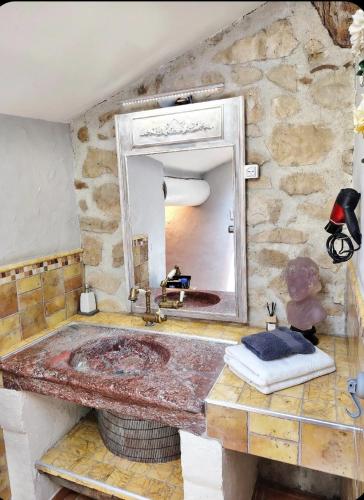 a stone bathroom with a large sink and a mirror at VILLA ARTEMIA - chambre d hôtes labellisée massages-piscine-climatisation in Sigean