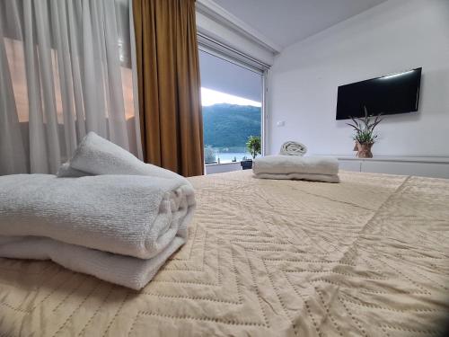a bedroom with a large bed with a large window at Vila Olive 51 in Tivat
