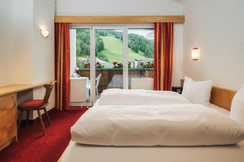 a hotel room with two beds and a window at Apart Waldblick in Serfaus
