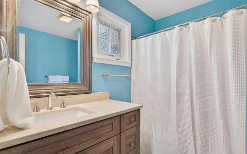 a bathroom with a sink and a shower curtain at Mischief Managed NC in Oak Island
