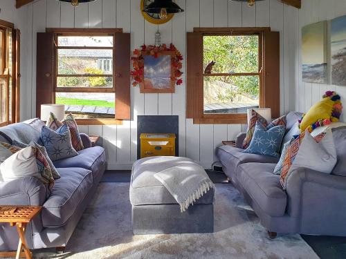 a living room with couches and a parrot sitting on top at Willow's Rest in Crafthole