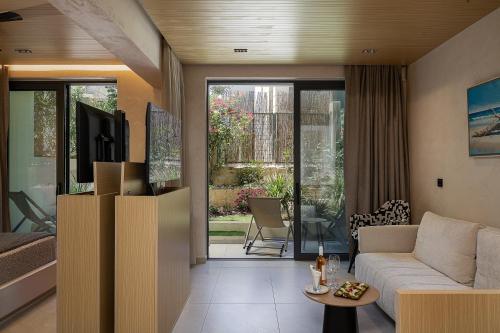 a living room with a couch and a tv at Pearl Beach in Rethymno