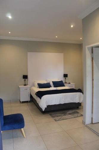a bedroom with a bed and a blue chair at Kanyane @ Graskop in Graskop