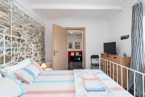 a bedroom with a bed and a stone wall at Με συμπάθεια-With sympathy - private parking in Kavála