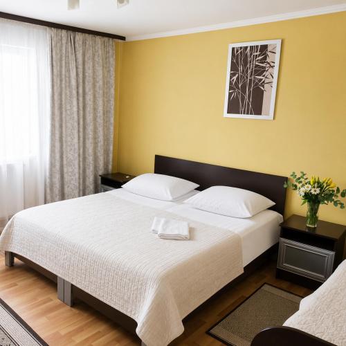 a bedroom with a large bed with white sheets at Хостел в Карпатах in Yasinya