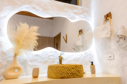 a bathroom with a mirror and a vase on a counter at MYLOS Hotel Boutique in Guatapé