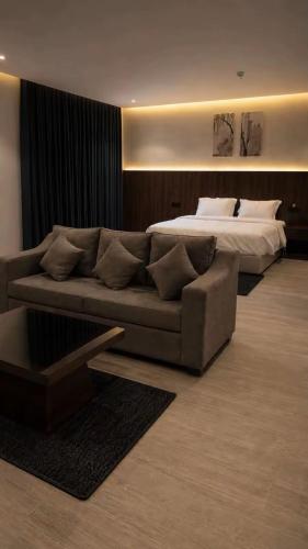 a living room with a couch and a bed at اجنحة الفخامة للشقق الفندقية in Taif