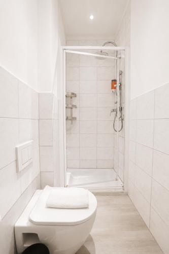 a white bathroom with a shower and a toilet at Core Luxembourg City in Luxembourg