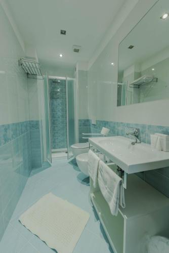 a white bathroom with a sink and a toilet at Park Hotel Perù ***S in Lido di Jesolo