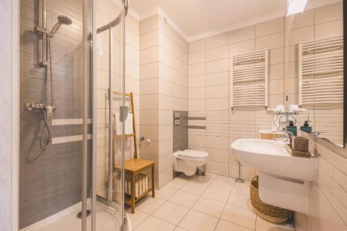 a bathroom with a shower and a sink and a toilet at Maritimo Apartament przy Porcie by 2HomeRent in Kołobrzeg