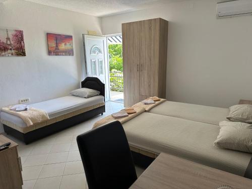a room with two beds and a table and a chair at Apartmani Čavor in Budva
