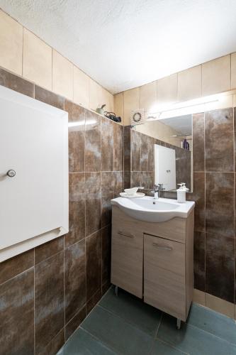 a bathroom with a sink and a mirror at Με συμπάθεια-With sympathy - private parking in Kavála
