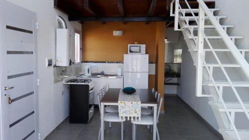 eine Küche mit einem Tisch und einem weißen Kühlschrank in der Unterkunft Duplex la Delfina 1 in Villa Carlos Paz