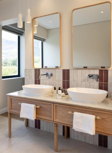 two sinks in a bathroom with a large mirror at Kleine Banhoek Manor in Stellenbosch