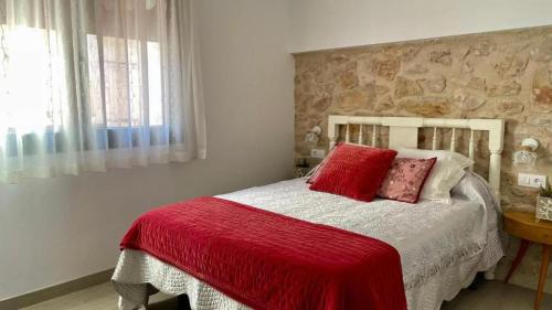 a bedroom with a bed with a red blanket at Les Casetes in La Senia