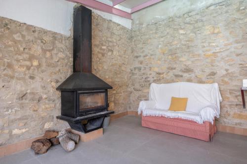 ein Wohnzimmer mit Holzofen und einem Stuhl in der Unterkunft Raízes 22 - Apartamento 1 in Puebla de Don Fadrique