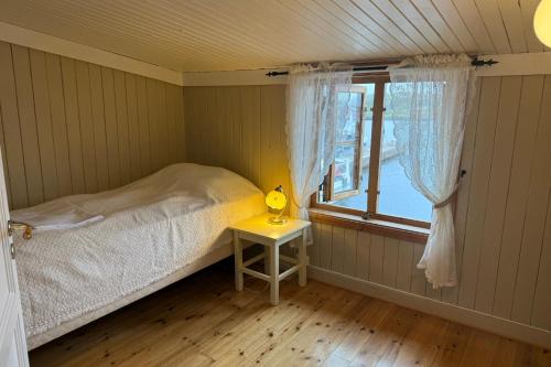 a small bedroom with a bed and a window at The traditional Burekka 17 - Lofoten in Stamsund