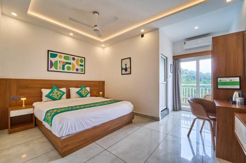 a bedroom with a bed and a desk and a balcony at Treebo Belita Resort Munnar With Infinity Pool in Munnar