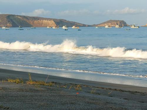 a group of boats in the water with a beach at La Fogata Bungalows in Machalilla