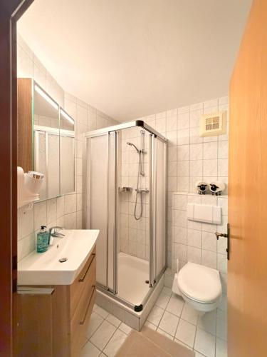 a bathroom with a shower and a toilet and a sink at Appartements Baumanngut in Wagrain