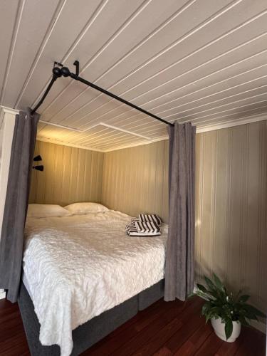 a canopy bed in a room with a ceiling at Sweet home in Kristiansund