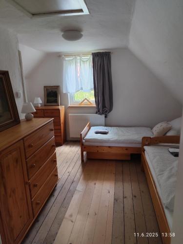 a bedroom with a bed and a dresser and a window at Chalupa Meduňka in Vsetín