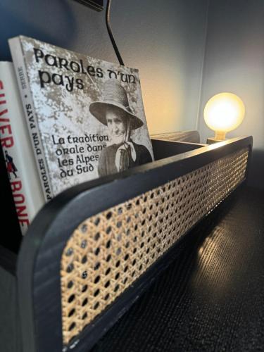 a book sitting on top of a bed with a lamp at Ostan Hôtel Boutique in Roquebillière