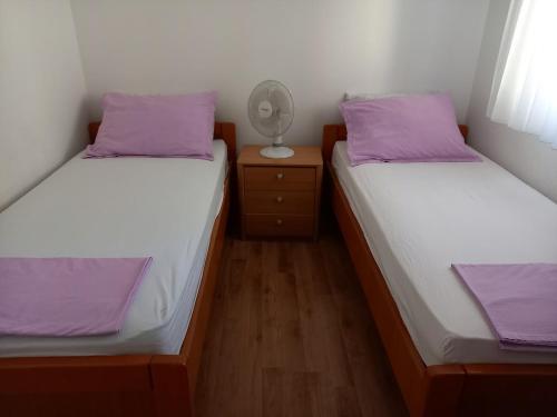 two twin beds in a room with purple pillows at Hilly house - Vis in Vis