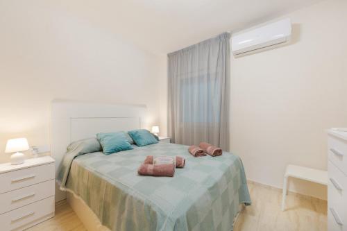 a bedroom with a bed with two towels on it at Apartamento de lujo Almerimar in Almerimar