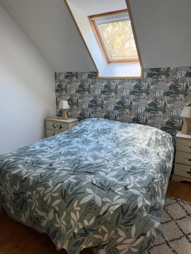 a bedroom with a bed with a green bedspread and a window at GITE EQUESTRE DE LA LANDE in Bréhal