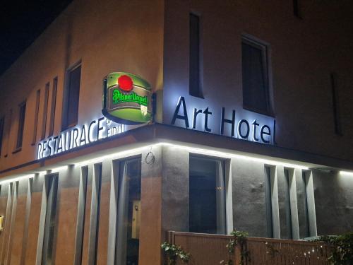 a building with an art hotel with a neon sign at Art Hotel Podebrady in Poděbrady