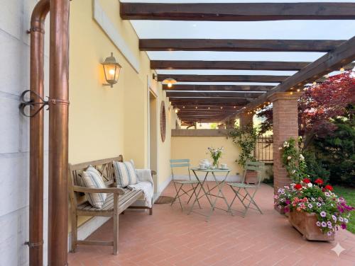 a patio with chairs and a table with flowers at La Piccola Atene Oasi in Strettoia