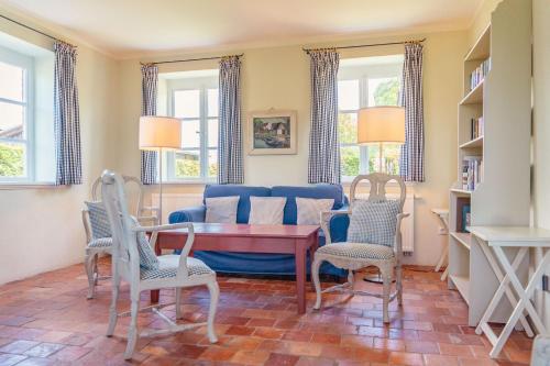 ein Wohnzimmer mit Sofa, Tisch und Stühlen in der Unterkunft Ferienwohnung Koppelblick III - Boldevitzer Rügenkaten in Parchtitz