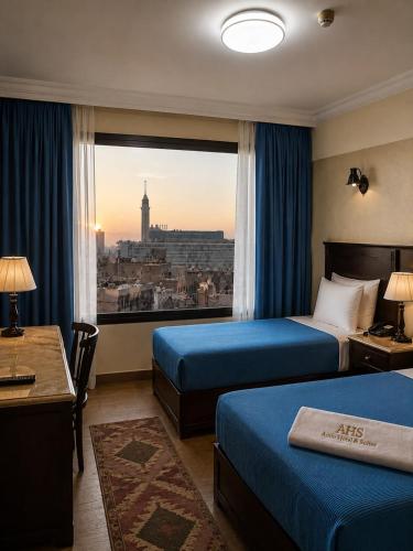 a hotel room with two beds and a view of a city at El Amin Hotel & Suites - Downtown Cairo in Cairo