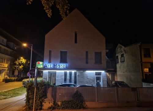 a building with an art hotel sign at night at Art Hotel Podebrady in Poděbrady
