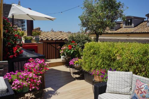 a patio with flowers and plants on a balcony at Hotel Caravita in Rome