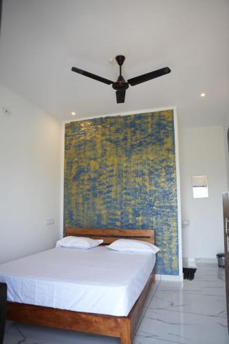 a bed in a room with a ceiling fan at Vagamon leafhill mountain view holidays in Vagamon